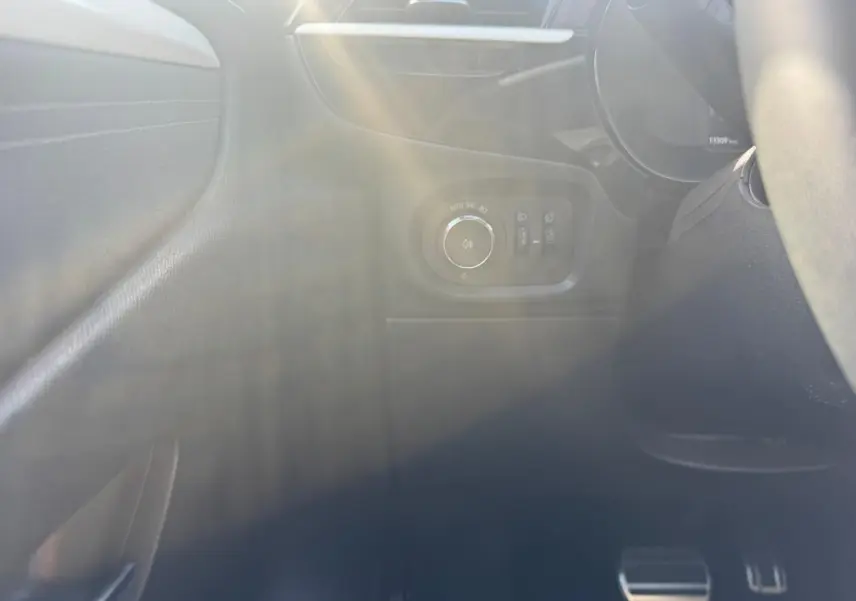 Détail intérieur côté gauche de l’Opel Corsa 2025 noir, montrant les commandes d’éclairage et les pédales en aluminium.