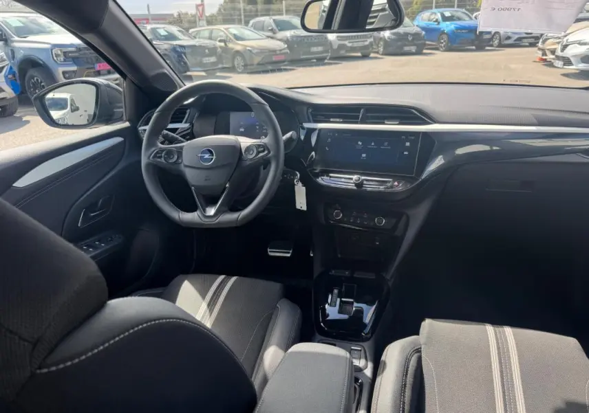 Vue intérieure avant de l’Opel Corsa 2025 noire, montrant le volant, tableau de bord digital et console centrale moderne.