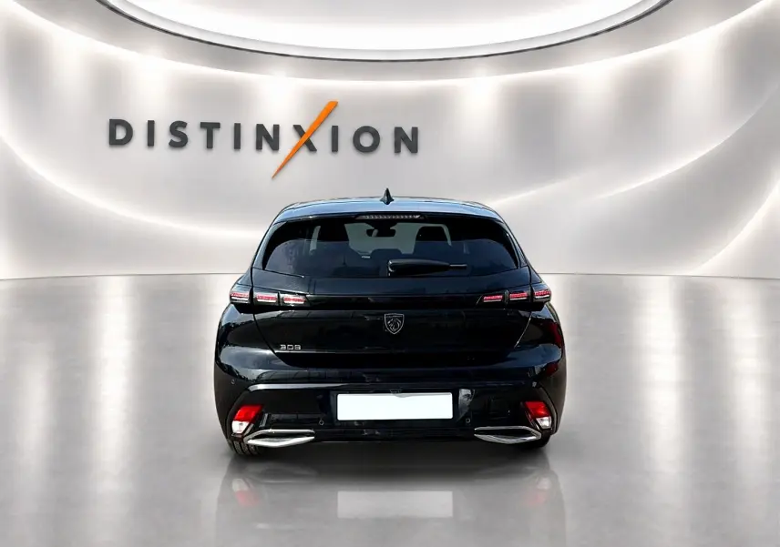 Vue arrière d'une Peugeot 308 noire 2025 avec feux LED et double sortie d'échappement chromée dans un showroom.