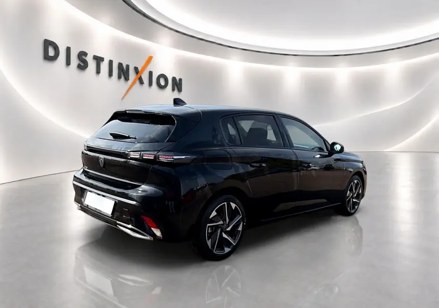PEUGEOT 308 noir en 3/4 arrière droit dans un showroom lumineux avec jantes alliage distinctives.