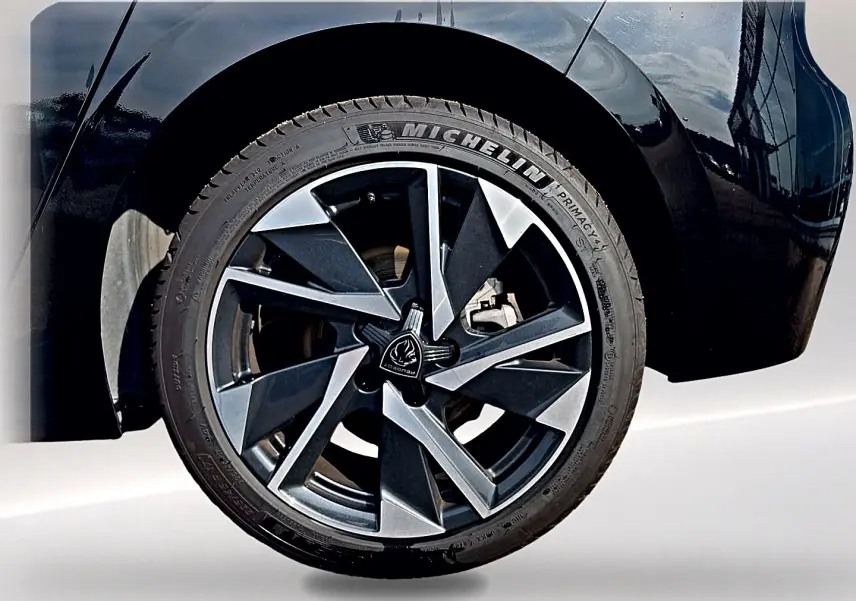 Gros plan sur la roue arrière droite noire de la Peugeot 308 2025 avec jante alu au design moderne bicolore.