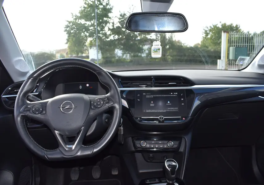 Vue intérieure frontale du tableau de bord et volant noir de l'Opel Corsa gris 2021 avec écran tactile central.