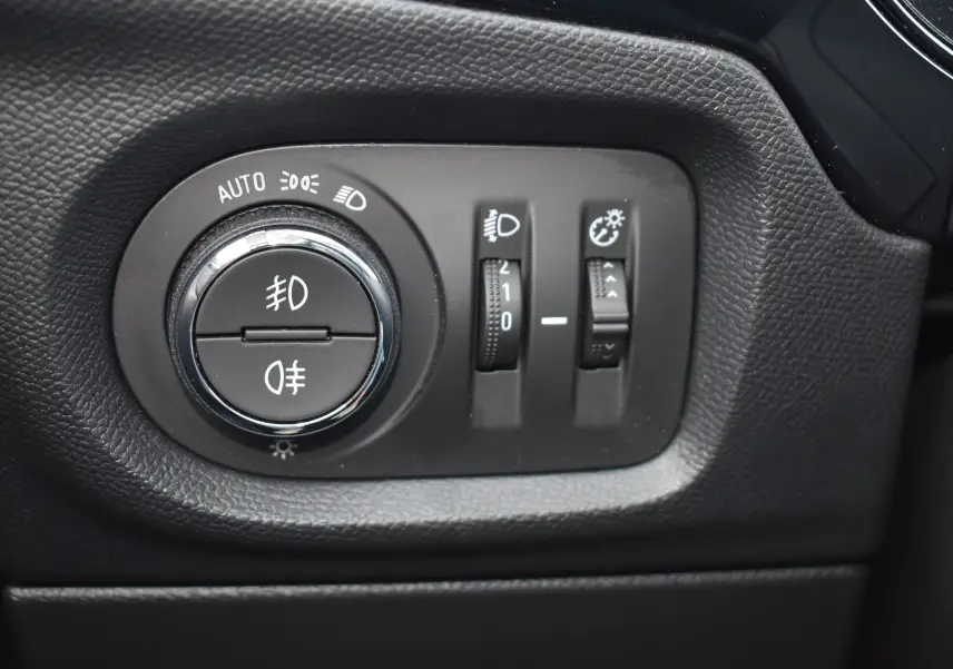 Gros plan sur le panneau de commande des phares de l’Opel Corsa gris 2021 avec réglages d’éclairage et de luminosité.