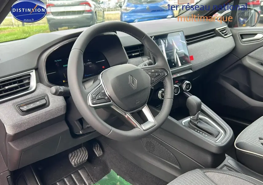 Intérieur Renault Clio V 1.6 e-tech 145 techno 2025, vue côté conducteur sur volant multifonction et console centrale.