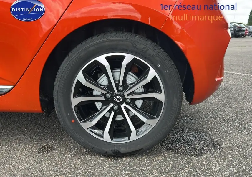 Gros plan sur la roue arrière droite de la Renault Clio V orange Valencia, mettant en valeur la jante alu au design moderne.