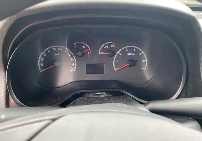 Vue rapprochée du tableau de bord noir de l'Opel Combo blanc, affichant compteurs vitesse, carburant et température.