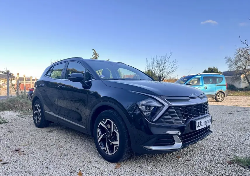Kia Sportage noir vu en 3/4 avant droit, avec calandre distinctive et jantes alliage modernes.