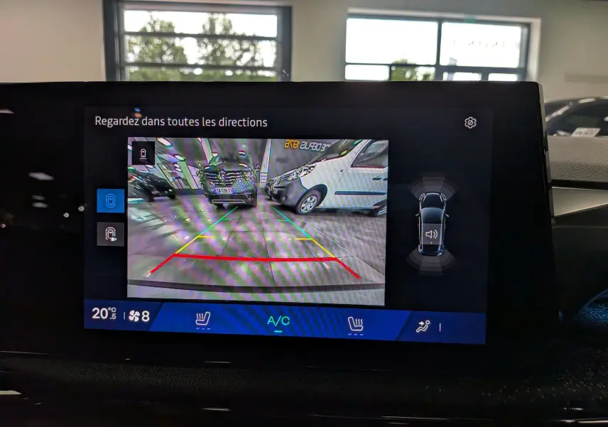 Vue de l'écran de la caméra de recul du Renault Clio VI TCe 115 Gris Rafale, avec guidage de trajectoire et capteurs visibles.