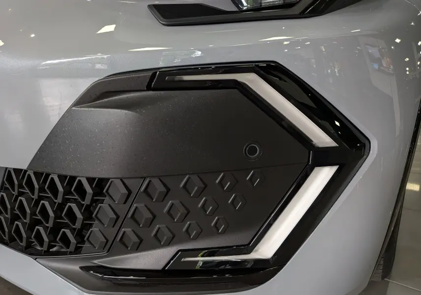 Gros plan sur le phare avant droit gris Rafale de la Renault Clio VI TCe 115 TECHNO avec signature lumineuse en forme de flèche.