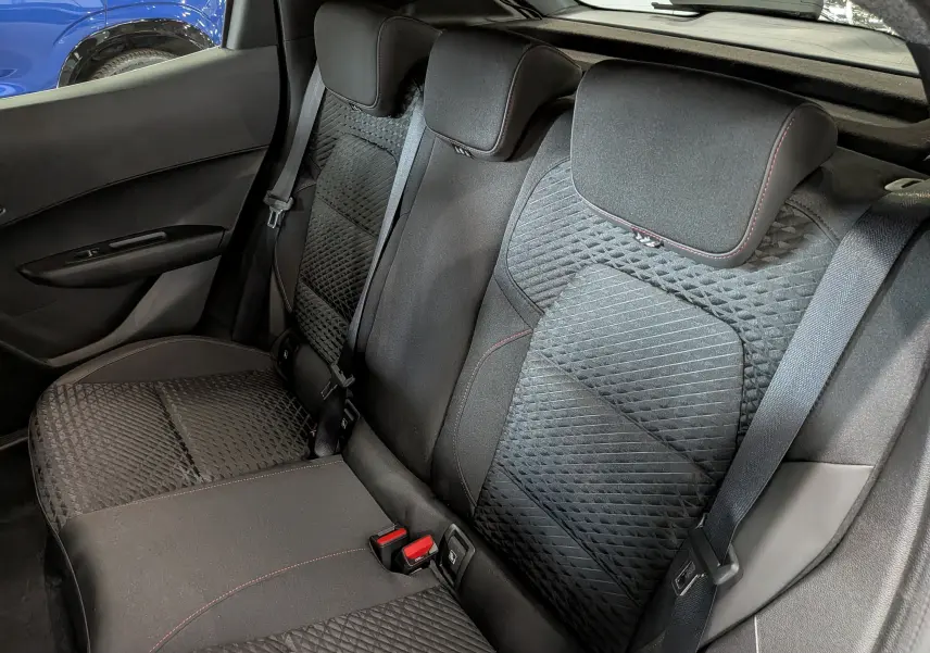 Vue intérieure des sièges arrière noirs avec surpiqûres rouges de la Renault Clio VI TCe 115 CH TECHNO 2026.