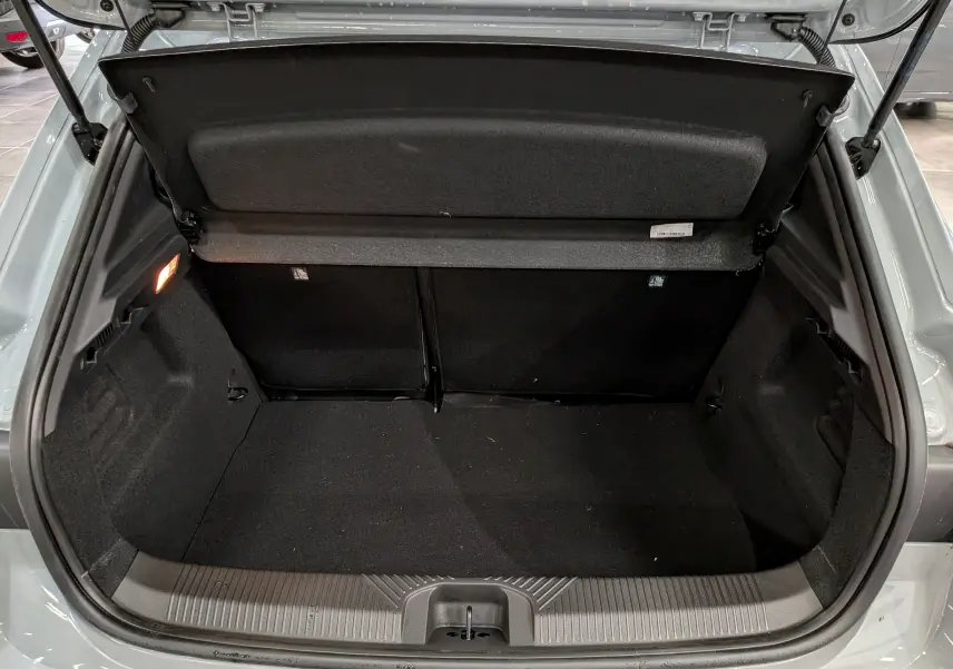 Coffre ouvert vu de l'arrière d'une Renault Clio VI TCe 115 Gris Rafale, montrant l'espace de chargement vide.