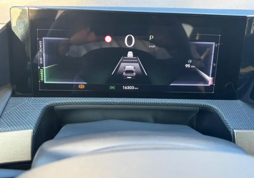 Vue rapprochée du tableau de bord numérique de la Lancia Ypsilon gris, affichant la vitesse et l'autonomie restante.