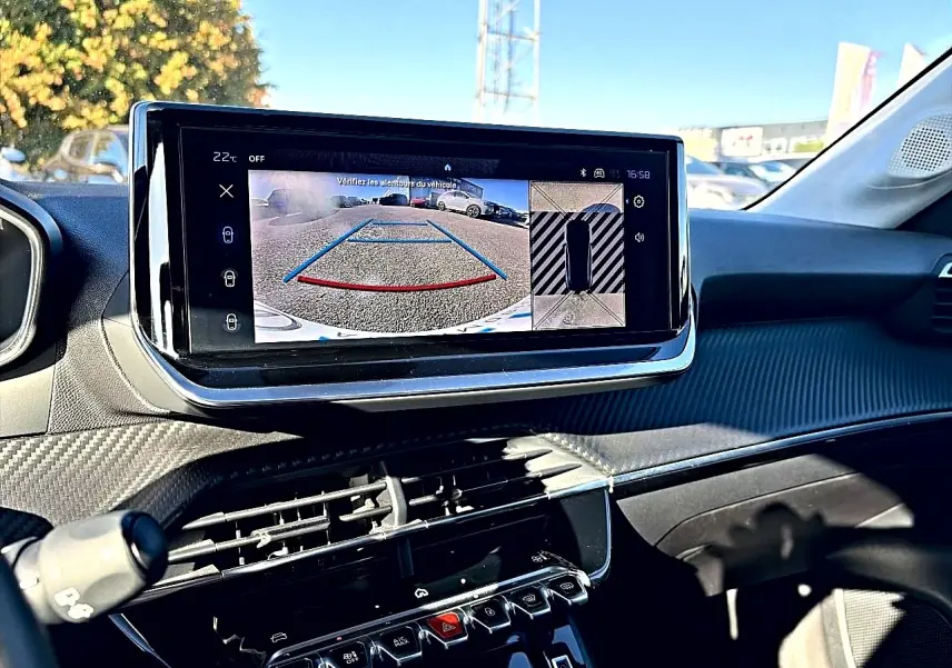 Vue intérieure du tableau de bord de la Peugeot 208 1.2 100 Allure avec écran tactile affichant la caméra de recul.