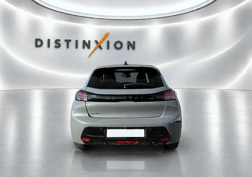 Vue arrière d'une Peugeot 208 gris selenium dans un showroom lumineux avec logo Distinxion en arrière-plan.