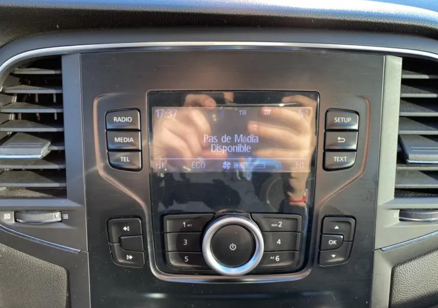 Tableau de bord central de Renault Mégane gris platine 2017 avec écran multifonction affichant "Pas de Média Disponible" et commandes autour.