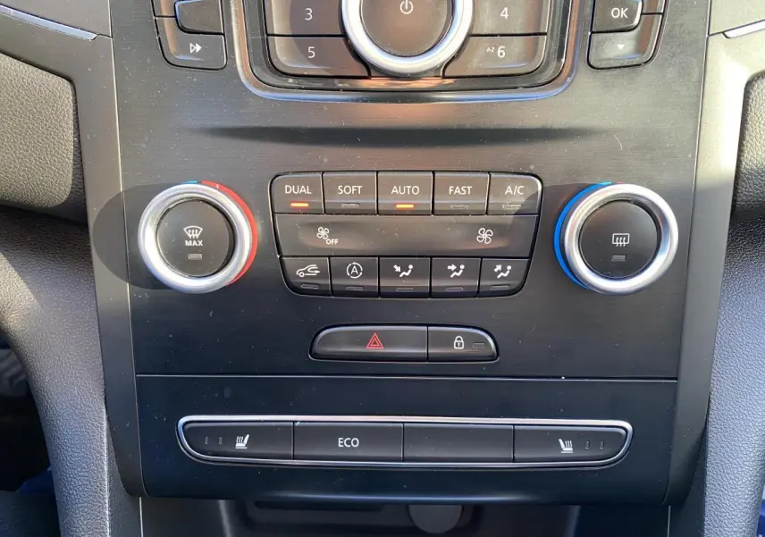 Détail de la console centrale noire de la Renault Mégane Sedan 2017 avec commandes de climatisation automatique et sièges chauffants.