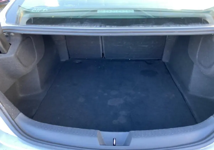 Vue plongeante sur le coffre vide d'une Renault Mégane Sedan gris platine, soulignant son espace de rangement.