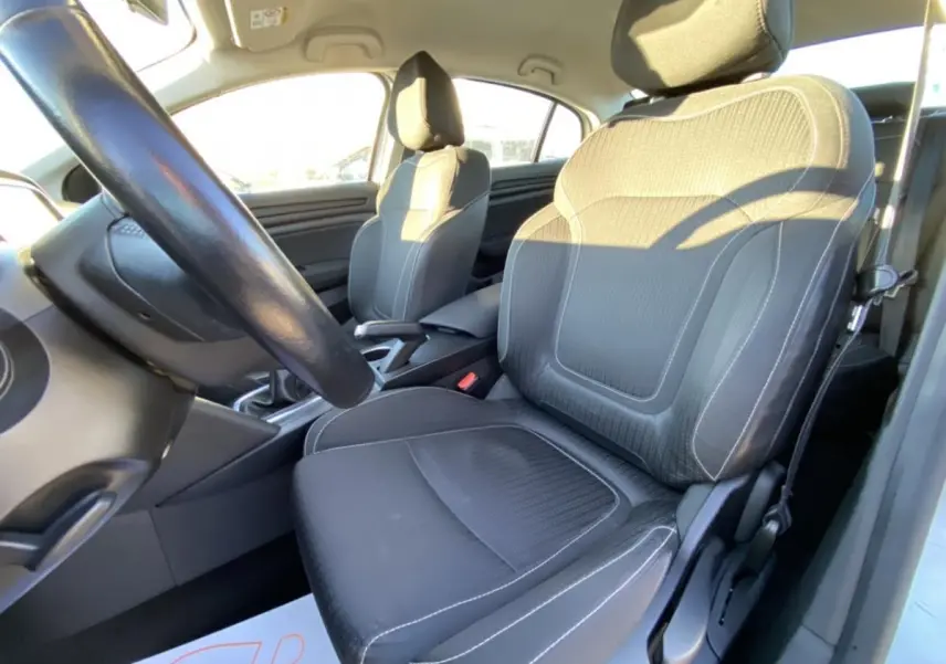 Intérieur de la Renault Mégane Sedan 2017, vue côté conducteur sur les sièges noirs avec coutures blanches et volant.