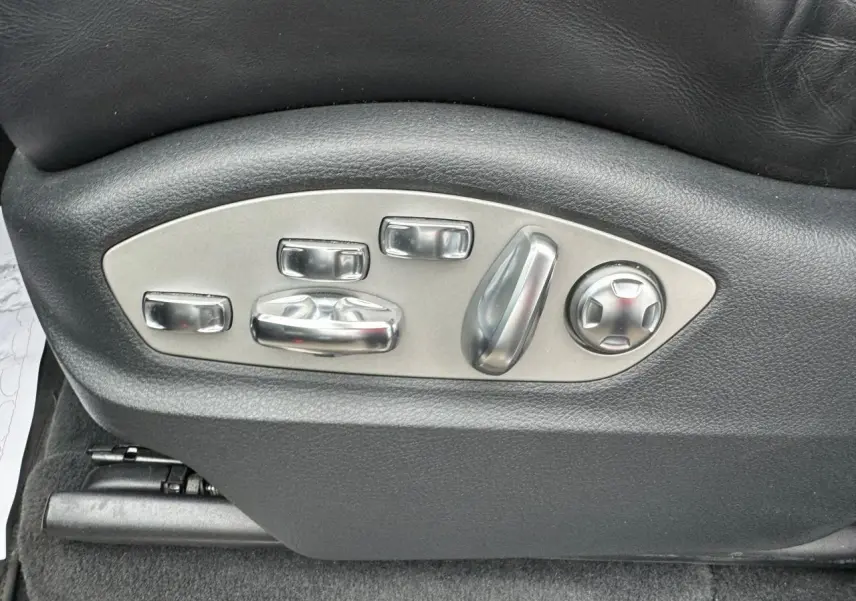 Gros plan sur les commandes de réglage électrique du siège en cuir noir d'un Porsche Cayenne S E-Hybrid 2017.