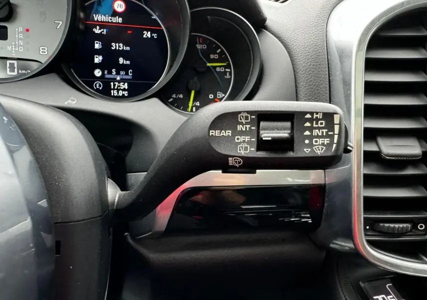 Gros plan sur le commodo d'essuie-glace à droite du volant dans l'habitacle noir du Porsche Cayenne hybride 2017.