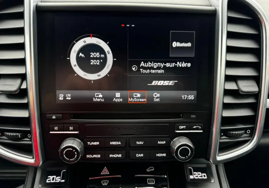 Vue rapprochée du tableau de bord du Porsche Cayenne noir 2017 avec écran central affichant navigation et son Bose.