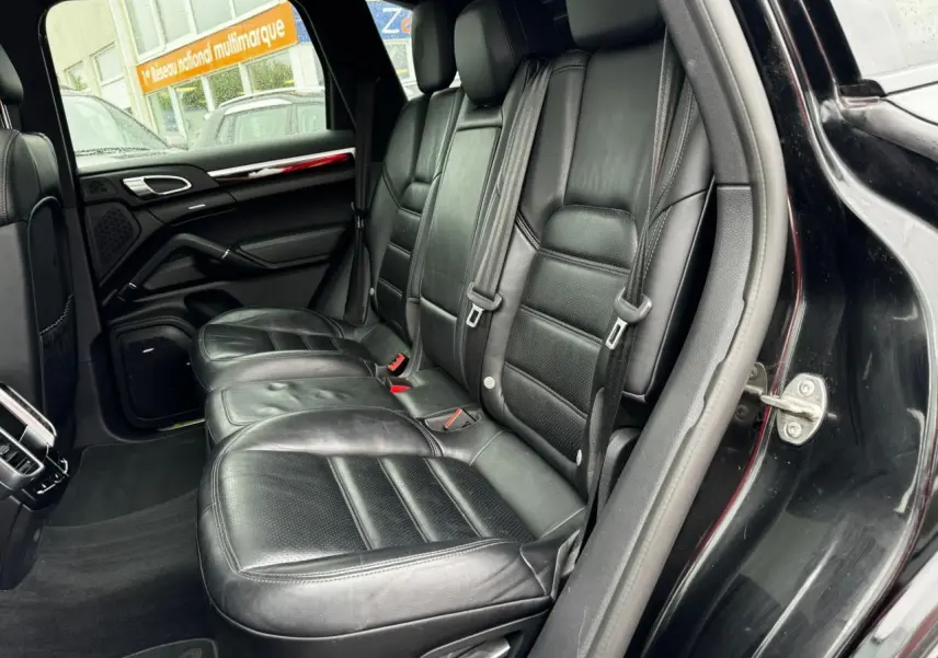 Vue côté droit sur les sièges arrière en cuir noir du Porsche Cayenne S E-Hybrid 2017 avec portière ouverte.