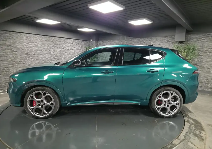 Profil côté gauche de l'Alfa Romeo Tonale 2024 vert Montreal avec jantes alliage 20 pouces et étriers de frein rouges.