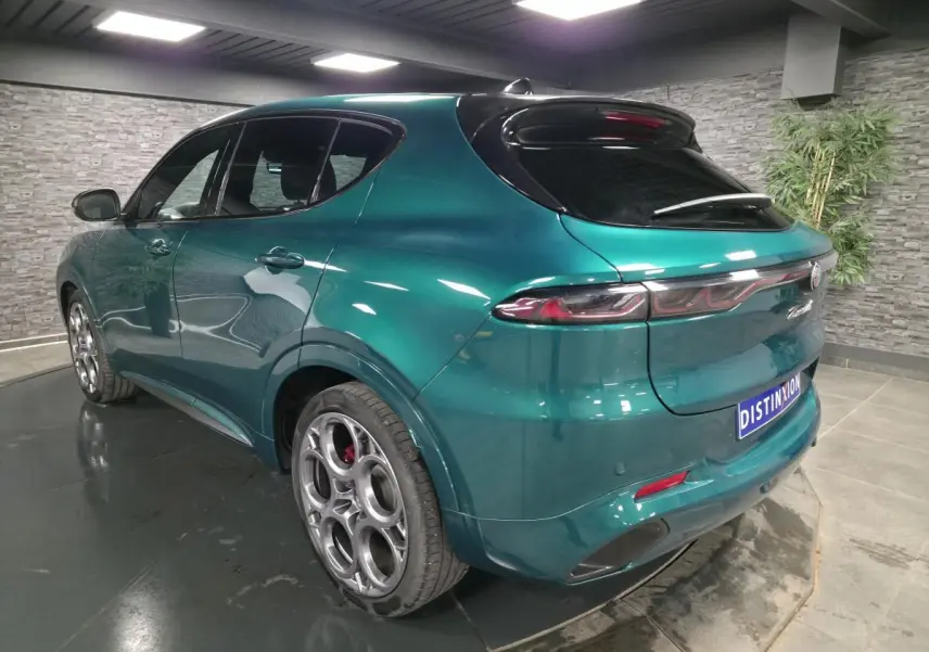 Vue 3/4 arrière droite d'une Alfa Romeo Tonale 2024 vert Montreal avec jantes 20 pouces et toit noir.
