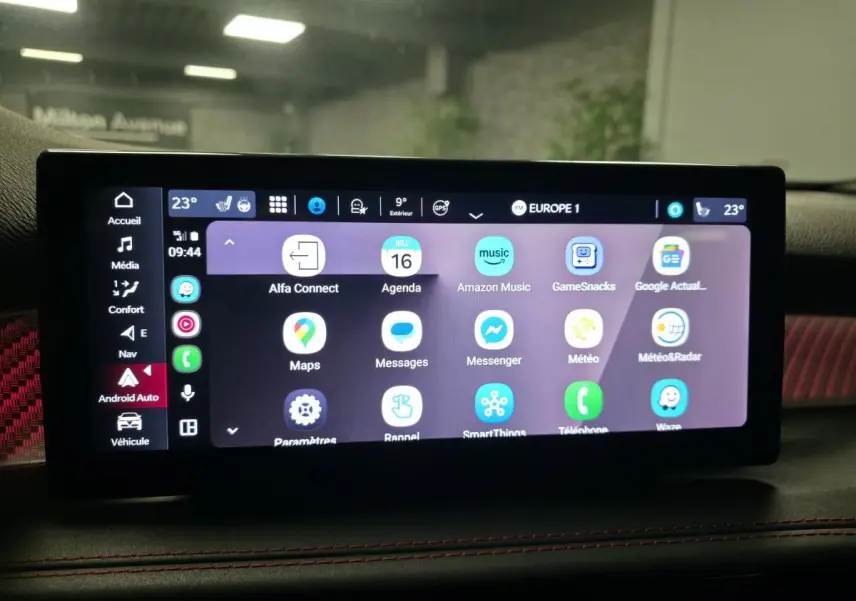 Écran tactile central affichant Android Auto dans l'Alfa Romeo Tonale 2024, avec surpiqûres rouges visibles sur le tableau de bord.