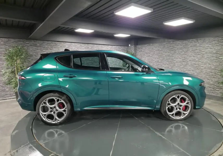 Profil gauche de l'Alfa Romeo Tonale 2024 vert Montreal avec jantes 20 pouces et étriers de frein rouges visibles.