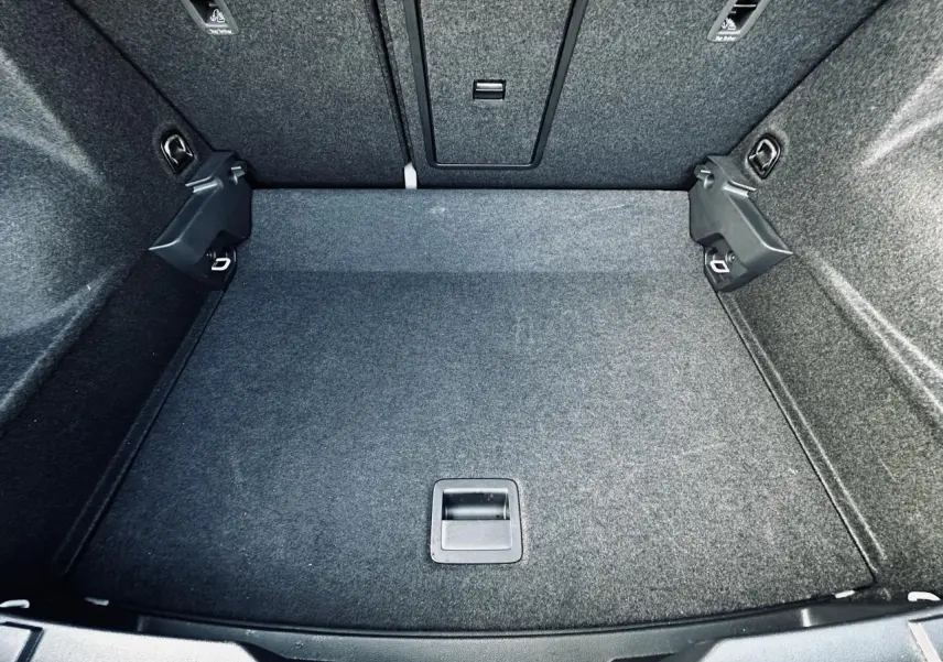 Coffre spacieux gris du Volkswagen T-Roc 2024, vue plongeante sur le plancher et les fixations ISOFIX.