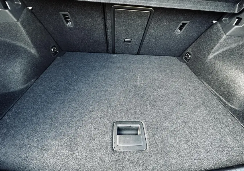 Vue intérieure du coffre gris du Volkswagen T-Roc 2024, montrant le plancher plat et les fixations ISOFIX.