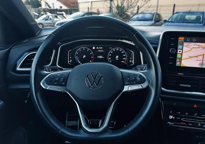 Vue frontale du volant cuir noir multifonction avec logo Volkswagen et tableau de bord digital du Volkswagen T-Roc 2024.