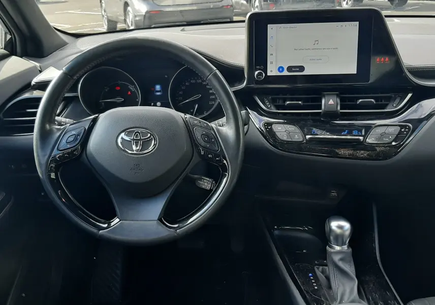 Vue intérieure côté droit des sièges arrière noirs en tissu du Toyota C-HR 1.8 Hybrid 2023 avec ceinture de sécurité visible.