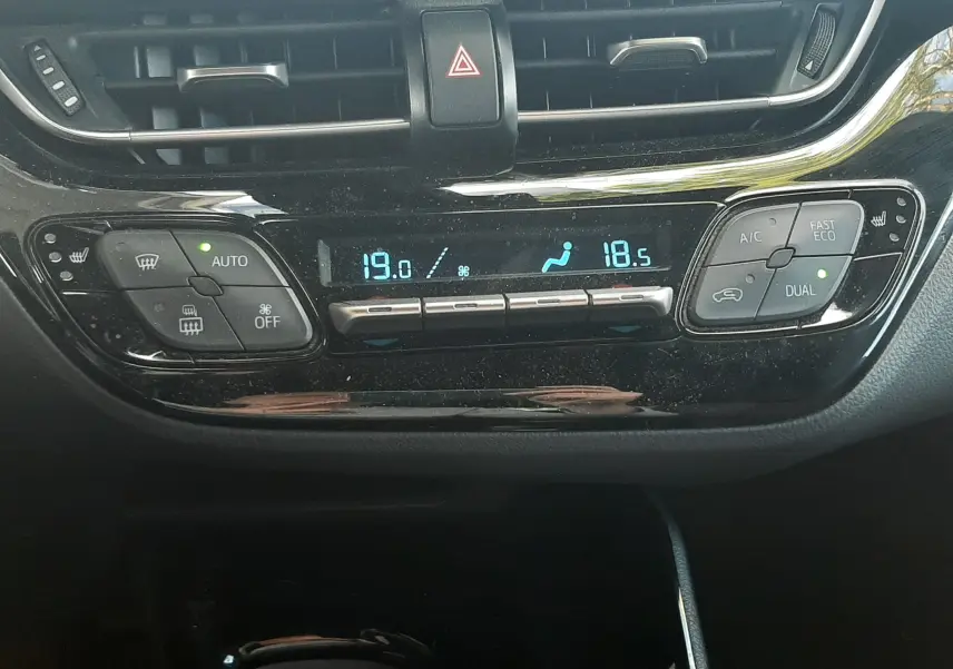 Gros plan sur les commandes noires au volant côté gauche du Toyota C-HR 1.8 Hybrid 2023, avec boutons multifonctions.