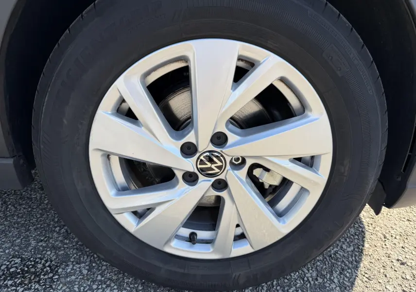 Gros plan sur la jante alliage argentée 16 pouces du Volkswagen Taigo bleu, avec logo VW au centre.