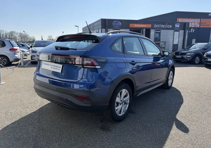 Vue 3/4 arrière droite d'un Volkswagen Taigo 2025 bleu métallisé avec jantes alliage et feux arrière LED.