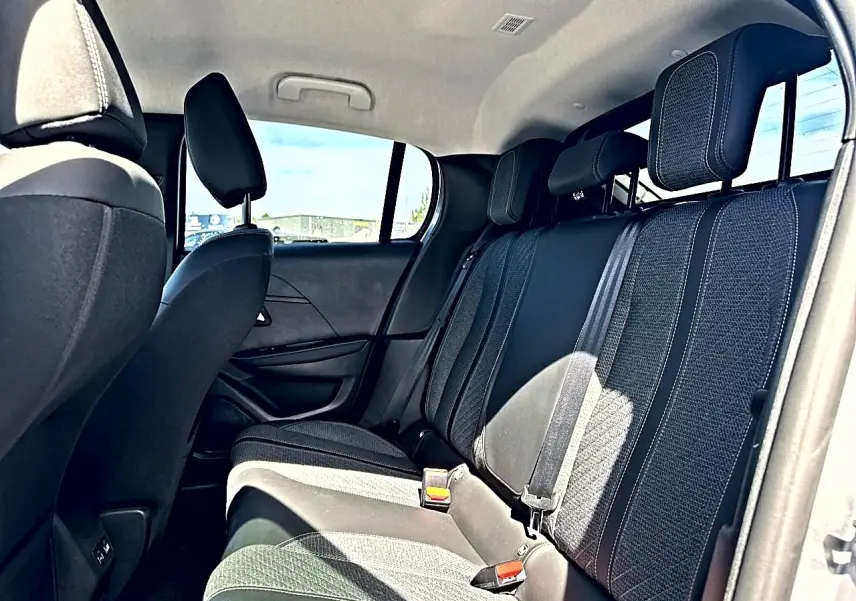 Vue intérieure côté droit sur la banquette arrière en tissu gris foncé de la Peugeot 208 1.2 100 Allure 2025.