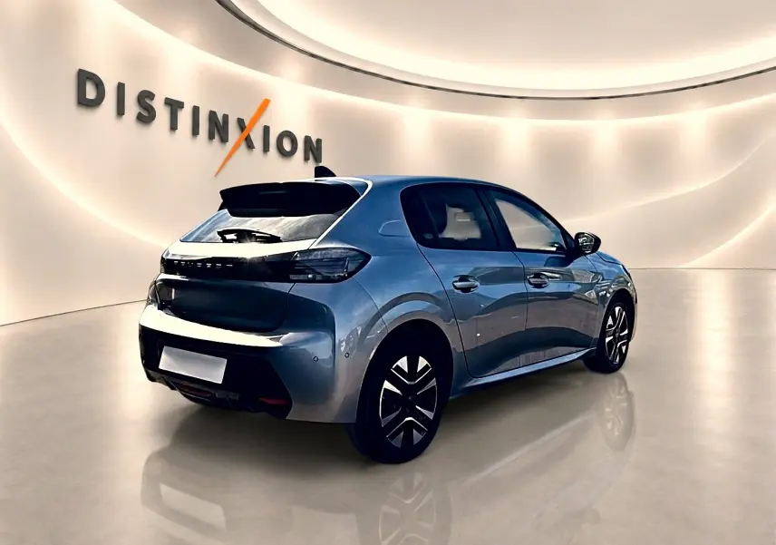 Peugeot 208 gris artense vue 3/4 arrière droit en intérieur avec jantes alu et feux arrière LED noirs.