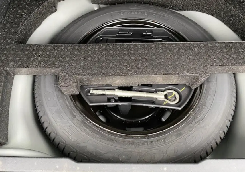 Gros plan sur la roue de secours en tôle noire du coffre du Peugeot 2008 gris foncé 2017.