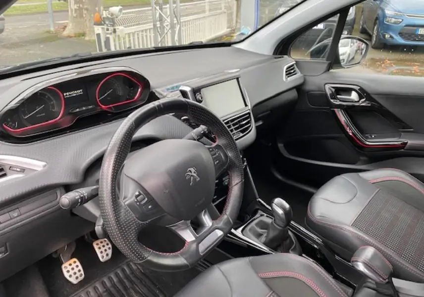 Intérieur de la Peugeot 2008 GT Line 2017, vue côté conducteur, volant cuir perforé et pédalier sport aluminium.