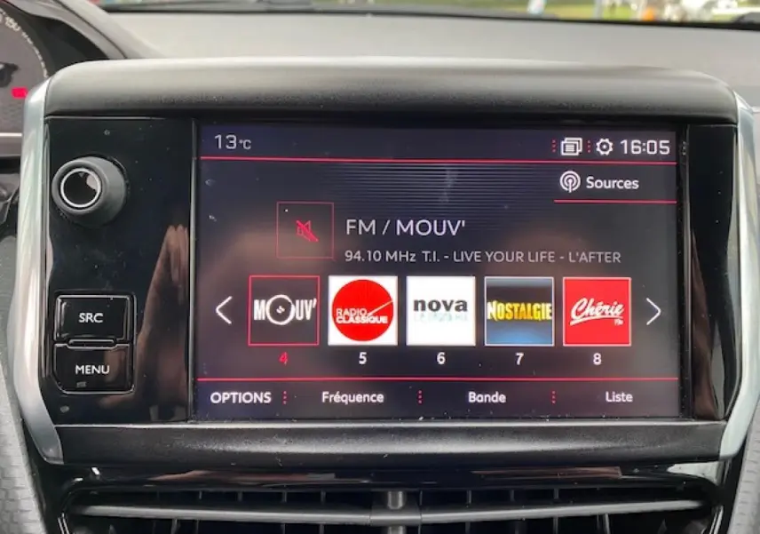 Écran tactile central du Peugeot 2008 gris foncé de 2017 affichant les stations radio FM en intérieur.