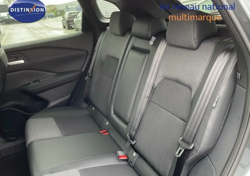 Vue intérieure des sièges arrière en tissu et cuir noir du Nissan Qashqai gris squale métal, avec ceinture de sécurité visible.