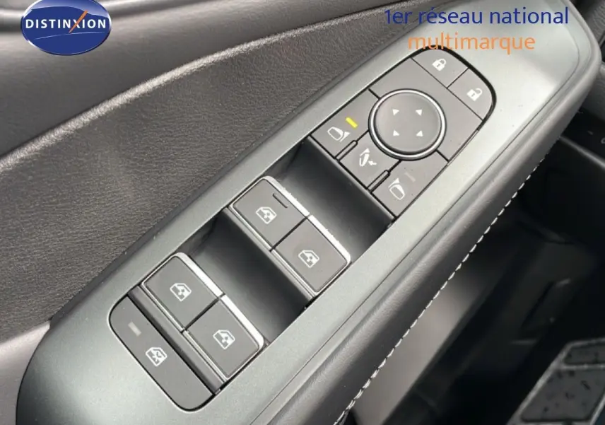 Gros plan sur les commandes de lève-vitres et rétroviseurs côté conducteur du Nissan Qashqai gris Squale Metal 2025.