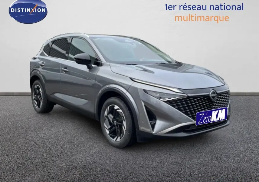 Vue 3/4 avant droit du Nissan Qashqai 2025 gris squale métal avec calandre noire et jantes stylisées.