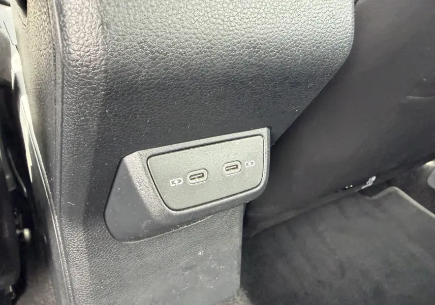 Vue rapprochée des ports USB-C de recharge situés à l'arrière de la console centrale d'une Volkswagen Polo bleue.