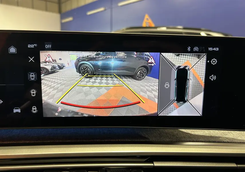 Vue écran multimédia montrant la caméra de recul et la vision 360° du Peugeot 3008 blanc Okenite en intérieur.