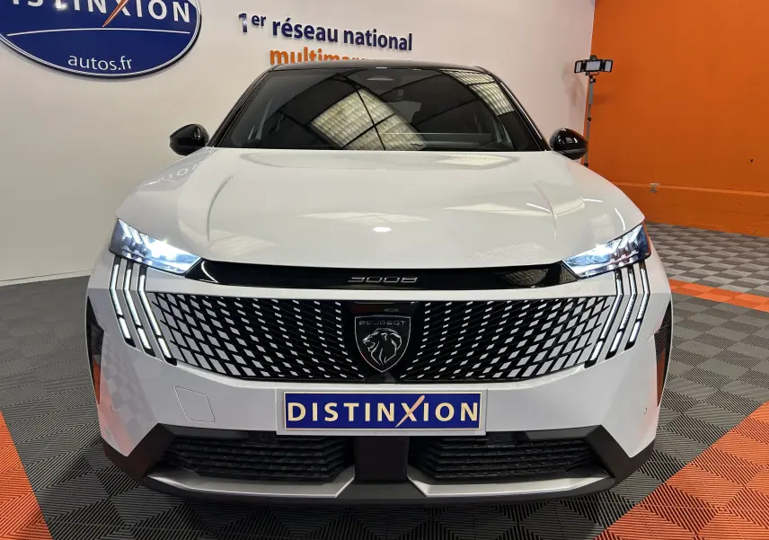 Vue frontale d’un Peugeot 3008 blanc Okenite avec calandre noire à motif géométrique et feux LED allumés.