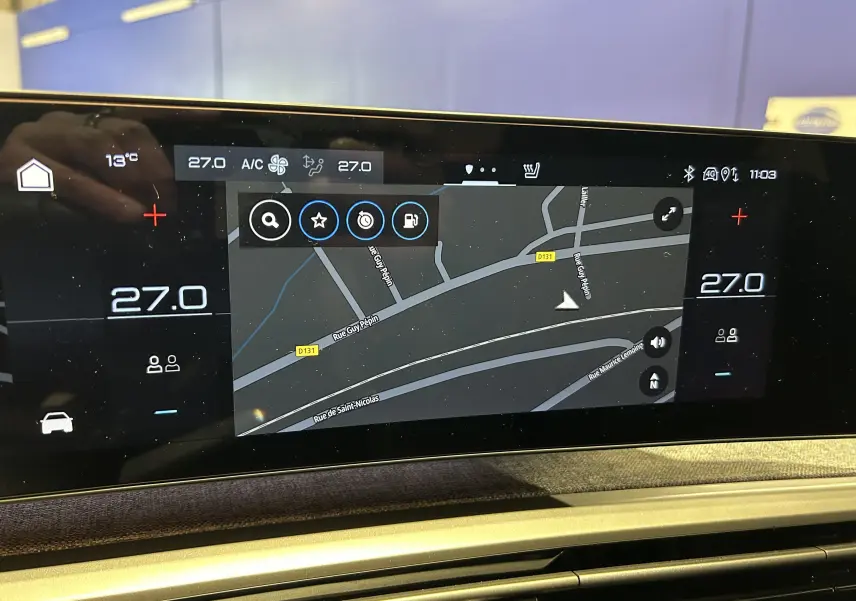 Écran tactile intérieur du Peugeot 3008 Hybrid 2025 affichant la navigation et la climatisation à 27°C.