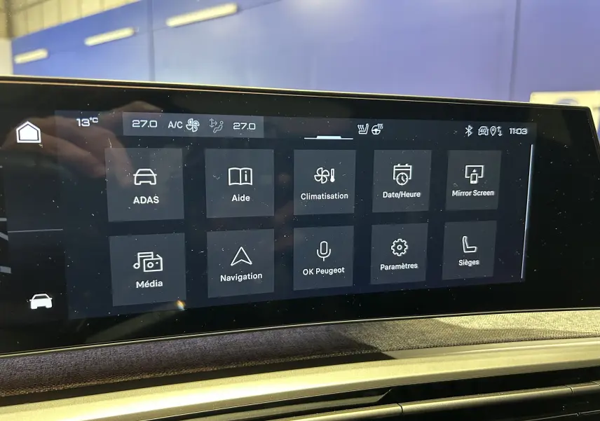 Écran tactile central du Peugeot 3008 Hybrid 2025 affichant les menus de climatisation, navigation et assistance à la conduite.
